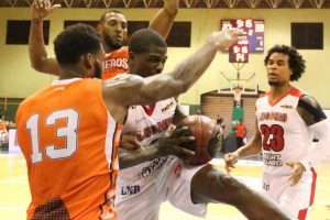 MJ Rhett (Leones) intenta penetrar ante la fuerte defensa de Cañeros